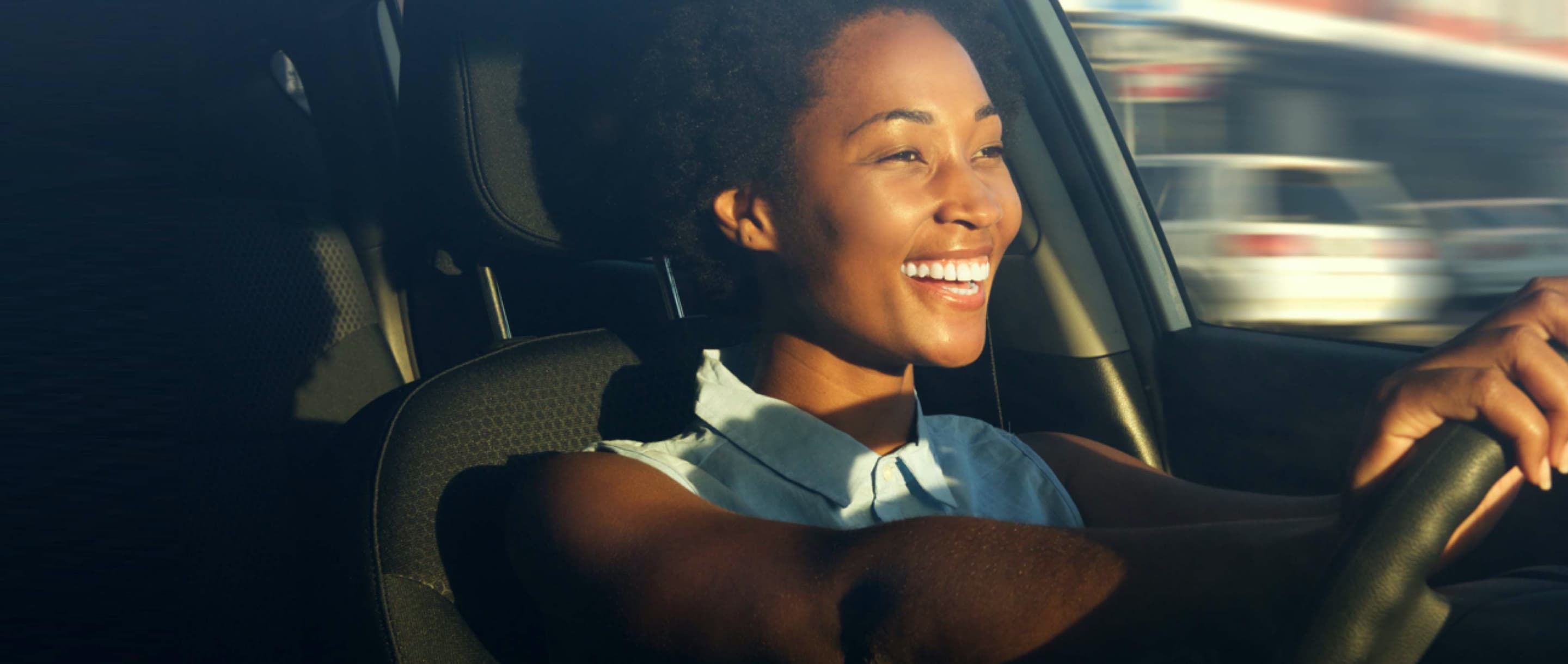 Woman driving car while smiling